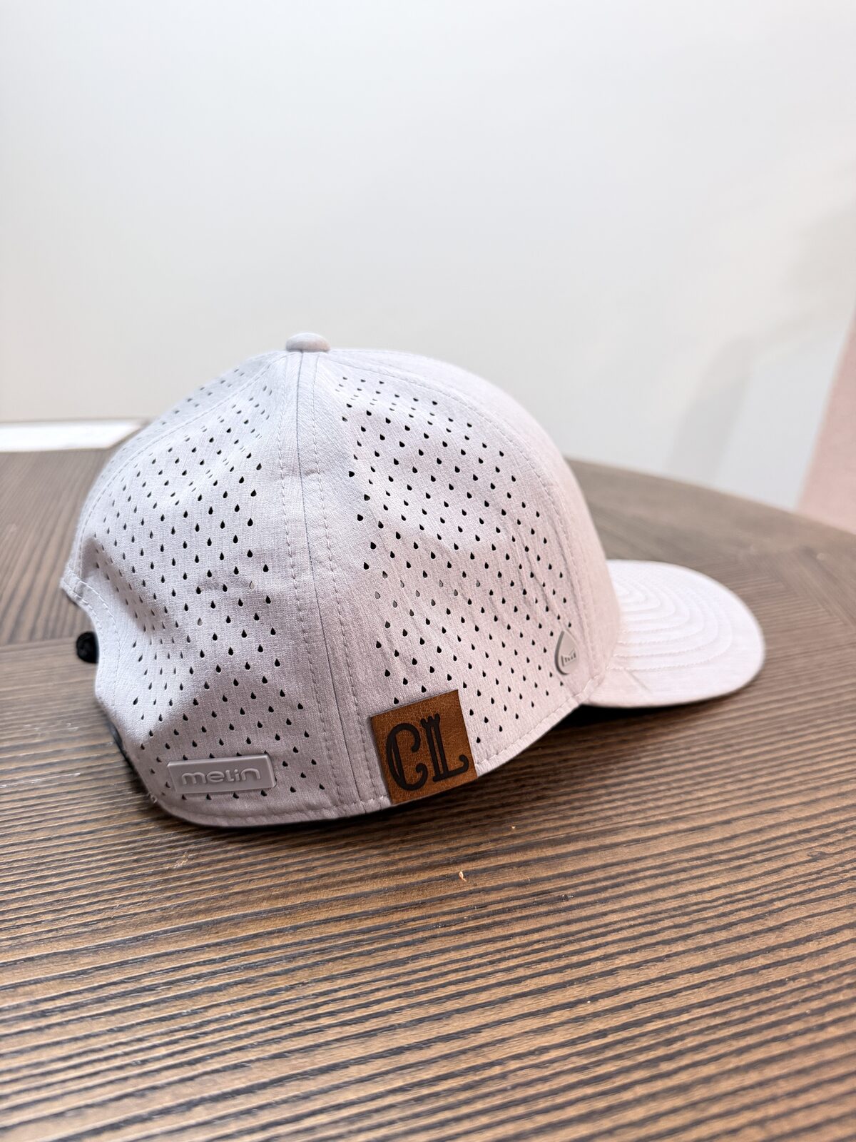 Custom leather patch pressed onto a cap at a wedding hat bar