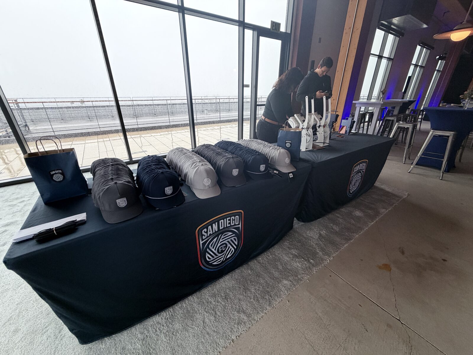 Table of finished custom caps displayed at a wedding hat bar